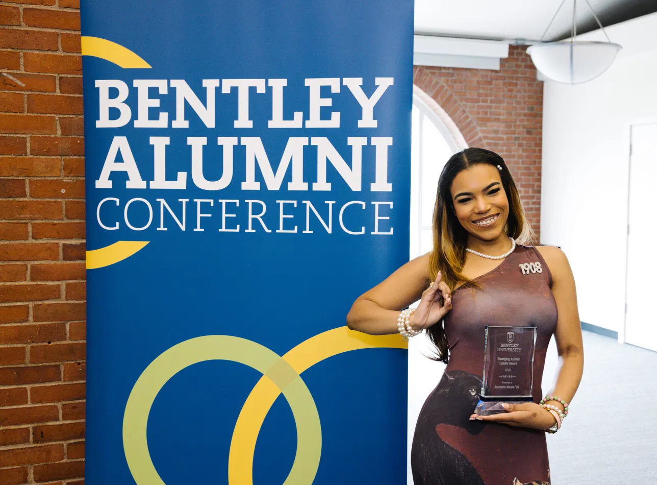 Jaychele holding her Emerging Alumni Leader Award at the Bentley Alumni Conference.